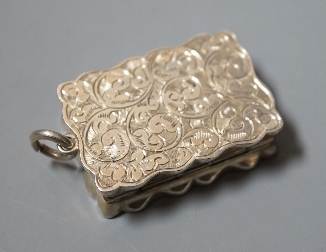 An Edwardian engraved silver shaped rectangular vinaigrette, Saunders & Shepherd, Birmingham, 1902, 38mm.